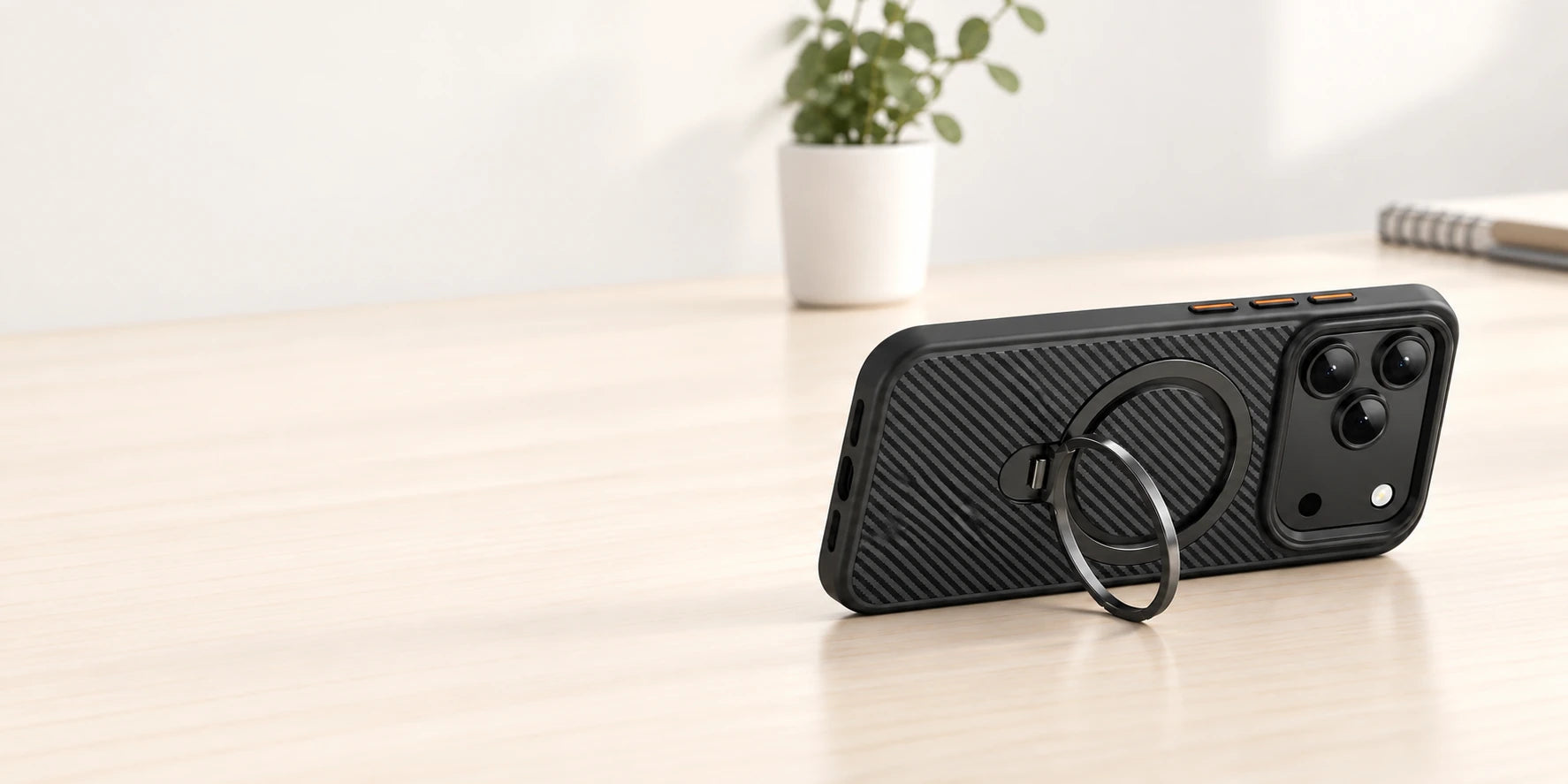Phone case resting in landscape with its original ring supporting it from the side.