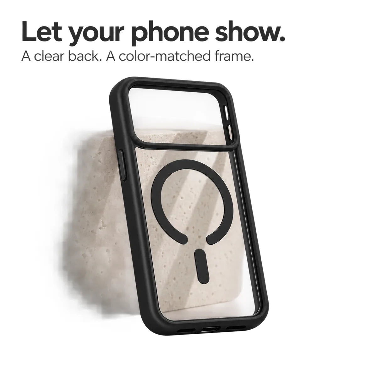 Black empty phone case showing its transparent back and magnetic ring against a pale stone block. #color_Midnight Black