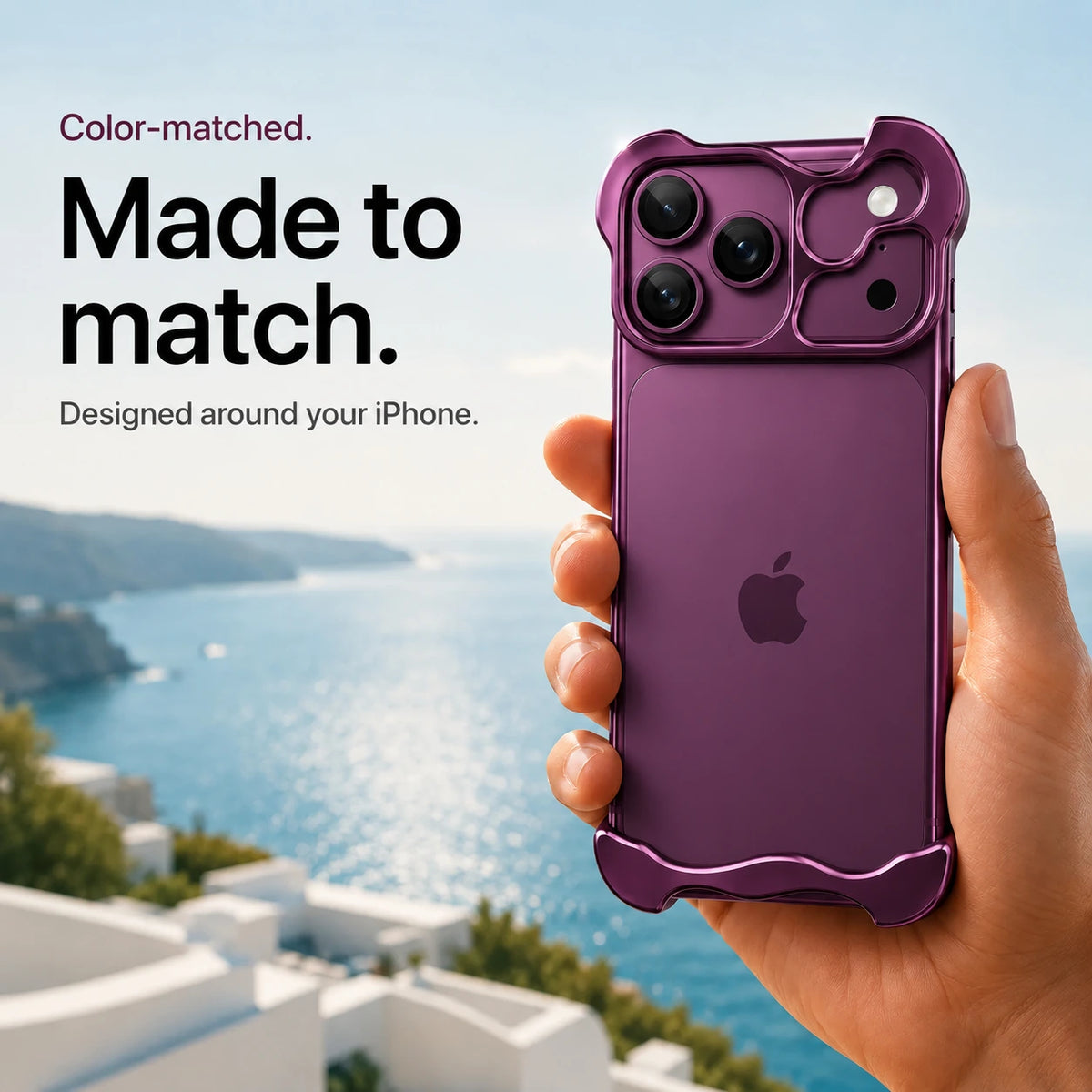 Dark purple sculpted metal phone case held in a hand above a coastal background #color_Dark Cherry