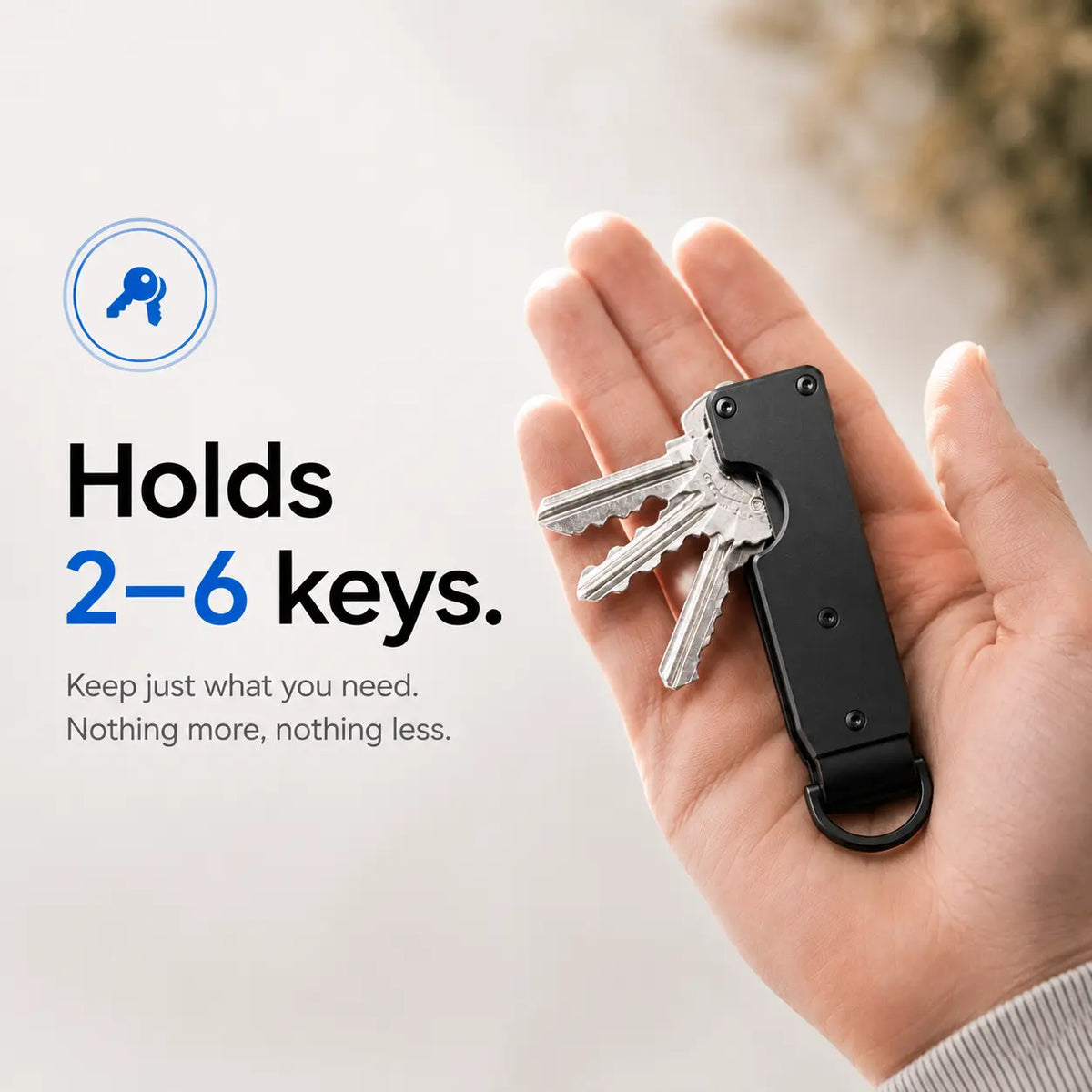 Stealth Black compact tracking key organizer holding several keys in a palm #color_Stealth Black