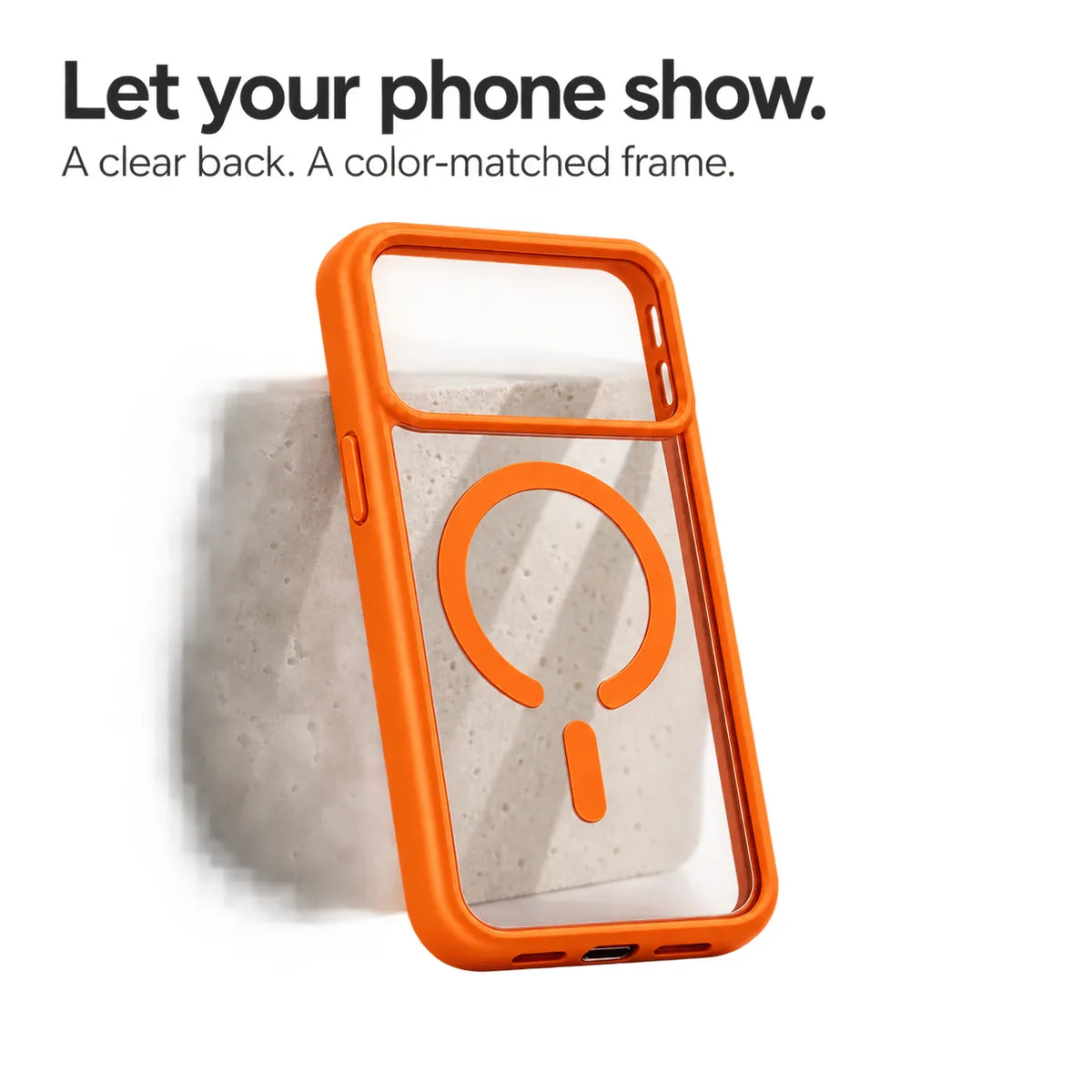 Orange empty phone case showing its transparent back and magnetic ring against a pale stone block. #color_Cosmic Orange