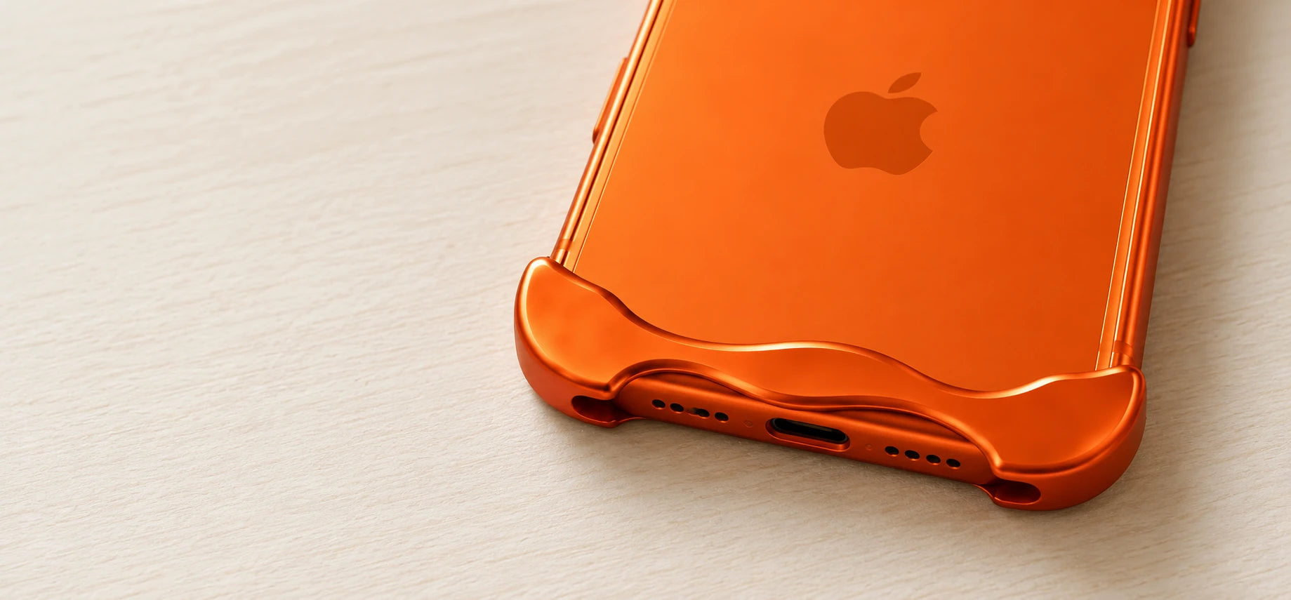 Close-up of the orange metal bumper around the phone's bottom edge and charging port.