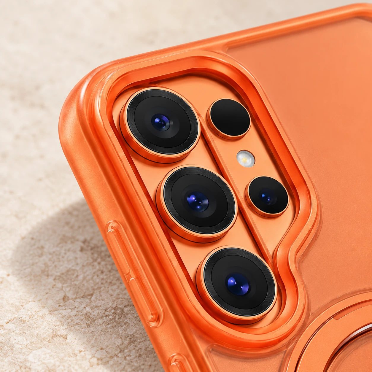 Close-up of the orange case edge around three vertically arranged camera lenses.