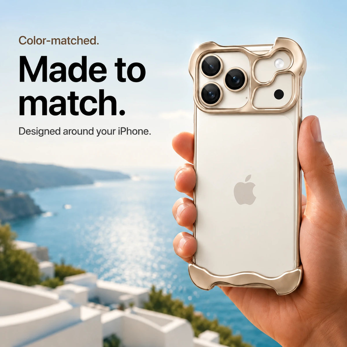 Sand gold sculpted metal phone case held in a hand above a coastal background #color_Desert Gold