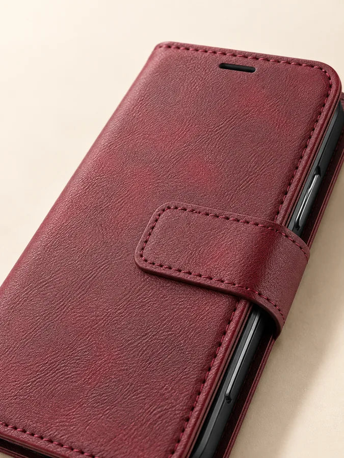 Close-up of the magnetic closure tab on the burgundy wallet folio.