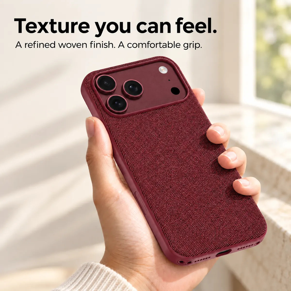 Hand holding a Burgundy woven phone case, showing its textured fabric finish. #color_Burgundy