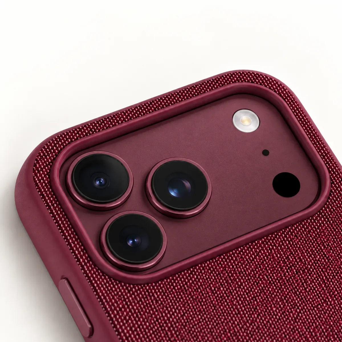 Close view of the raised Burgundy case rim around a matching Burgundy iPhone camera platform.