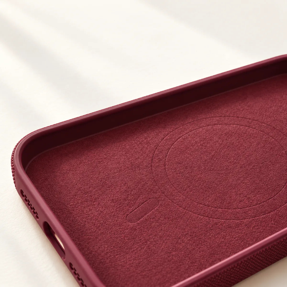 Close view of the soft fabric lining inside an empty Burgundy phone case.